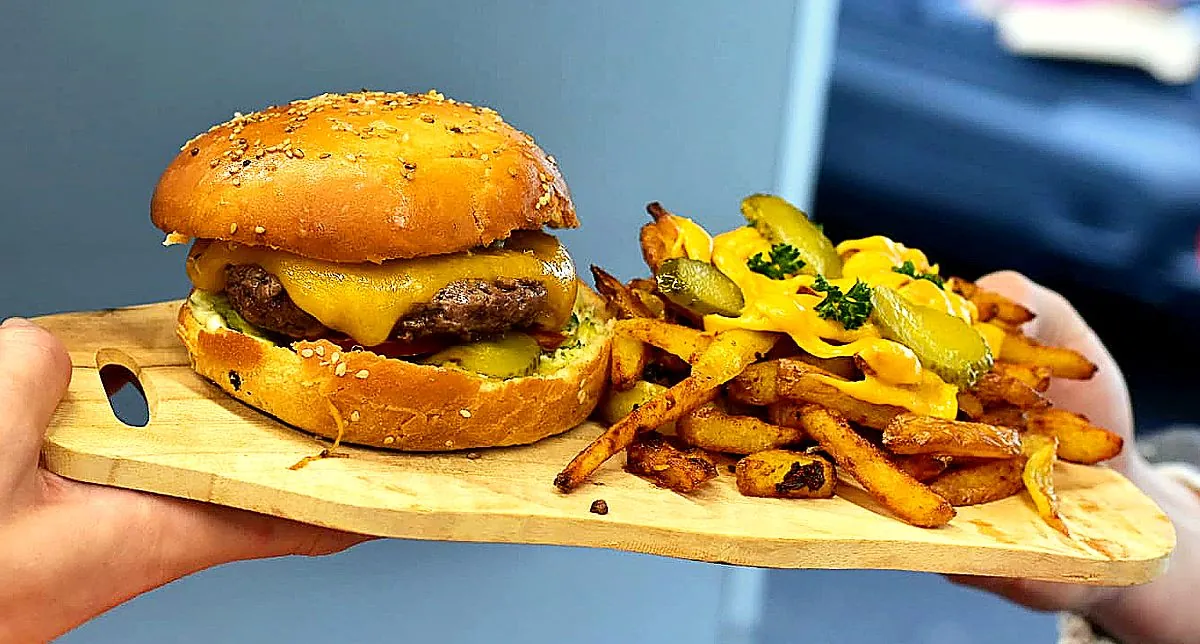 Cheeseburger et frites maison au cheddar sur planche en bois